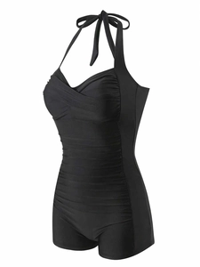 Close-up of ruched front detailing and slimming halter neck on black one-piece swimsuit