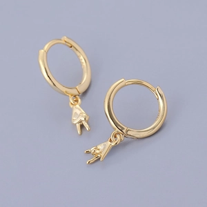 Macro view of gold S925 sterling silver hoop earrings with rock and peace sign charms