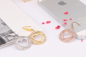 Detailed close-up of hollow heart circular earrings in gold, silver, and rose gold finishes