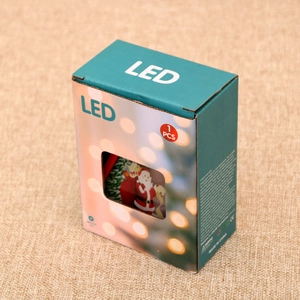 Detailed retail packaging of Christmas LED lantern showing Santa Claus patterns and specs