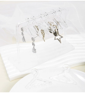 Detailed view of clear acrylic earring organizer with mini hanger style hooks for jewelry
