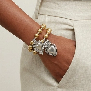 Gothisches zweilagiges Goldperlenarmband mit Vintage-Herzanhängern am Handgelenk