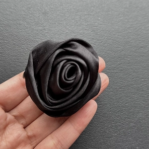 Detailed view of handmade black satin rose brooch with multi-layered 3D floral petals