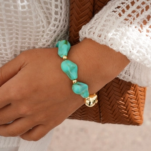 Gros plan du bracelet bohème avec perles turquoise et pendentif cœur doré