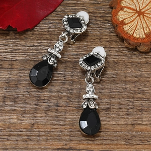 Vintage bohemian clip-on earrings with black waterdrop stones on rustic wood