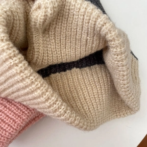 Macro view of beige and pink chunky knit texture on this winter balaclava hood