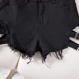 Detalle de pantalones cortos vaqueros negros con dobladillo deshilachado y hebilla lateral