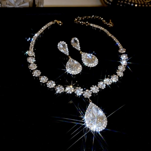 Detailed macro shot of sparkling pear-shaped crystal necklace and earrings on dark surface