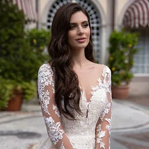 Elegant white lace wedding dress with deep V-neck and long sleeves in outdoor scenery