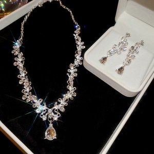 Close-up of diamond flower hollow water drop pendant necklace and earrings set