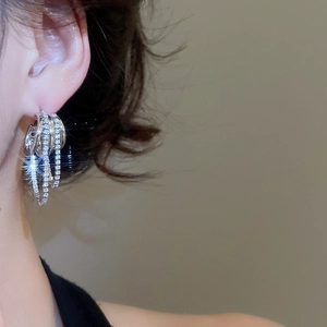 Gros plan de boucles d'oreilles multicouches en argent avec pampilles en zircon brillant