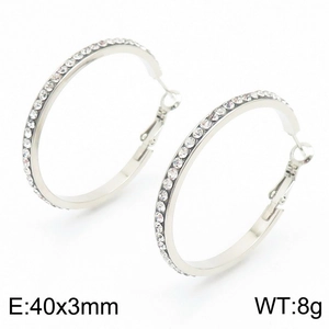 Boucles d'oreilles créoles argentées de 40mm serties de zircons sur fond blanc épuré