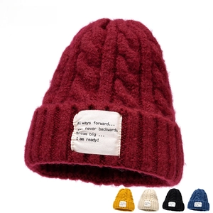 Detailopname van een grof gebreide beanie met textielpatch in diverse kleuren