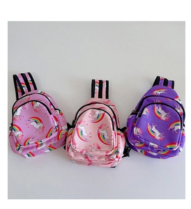 Vista plana de bolsos de pecho de lona con unicornios rosa y morado y estampados de arcoíris