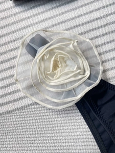 Detailed shot of 3D white organza floral appliqué on dark blue bikini swimwear fabric