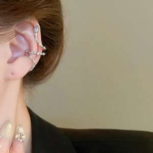 Detail of silver layered spiral ear cuff with zircon stones worn on the ear bone