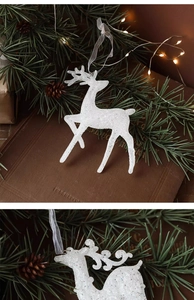 Gros plan d'un renne de Noël blanc pailleté avec ruban sur un sapin de Noël décoratif