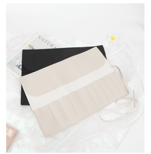Detail view of lychee-textured PU leather makeup brush roll bag with secure wrap tie