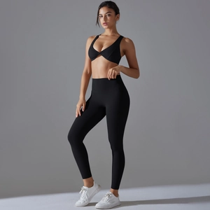 Detail of high-elastic black yoga set featuring twist-front bra and high-waist leggings