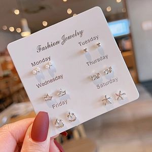 Close-up of 6-pair silver earring set with heart and flower designs on a display card