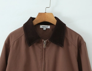 Detail of a brown jacket featuring a dark brown corduroy collar and M size neck label