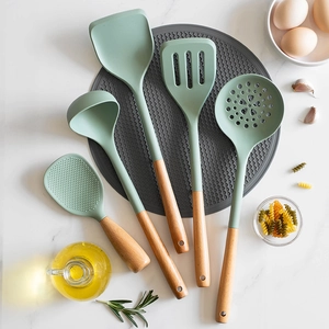 5-piece green silicone kitchen utensil set with wooden handles on marble surface