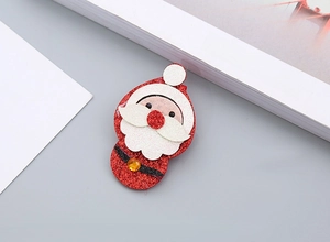 Détail d'une pince à cheveux Père Noël à paillettes rouges brillantes avec petit gemme