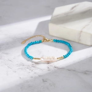 Detailed shot of baroque freshwater pearl and blue turquoise beads on 14K gold plated bracelet