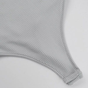Detail of gray ribbed knit bodysuit featuring high-quality stitching and fabric texture
