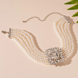 Detailed macro view of a 5-strand pearl necklace with a large crystal centerpiece