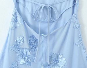 Détail de robe bleu clair avec broderie ruban 3D et fermeture à lacets au dos