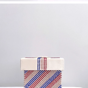 Macro shot of striped rhinestone evening clutch bag with red, blue, and silver crystals