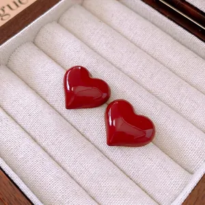 Vintage heart earrings in deep red enamel finish on white velvet jewelry box