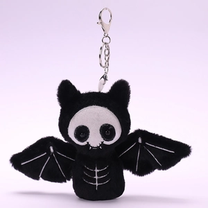 Detailed macro view of black bat plush keychain with white skeleton embroidery and metal clasp