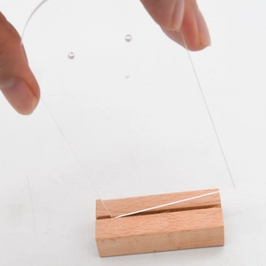 Vue détaillée du support de boucle d'oreille en acrylique inséré dans la base en bois