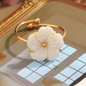 Detailed view of an 18K gold-plated adjustable flower ring with white shell petals