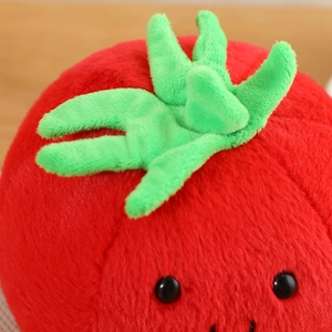 Close-up of cute plush tomato toy with soft red fabric and green leaf details