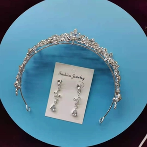 Detailed macro shot of silver bridal tiara and matching teardrop rhinestone earrings