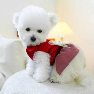 Detail of red satin dog dress with multilayer white mesh skirt and bow for small dogs