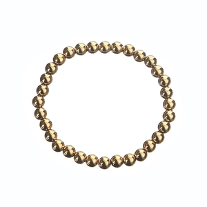 Macro shot of minimalist gold stainless steel beaded bracelet with polished finish