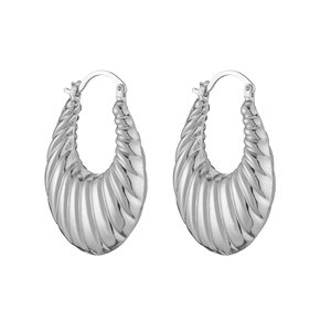 Macro shot of silver croissant hoop earrings with a textured wavy surface and secure clasp