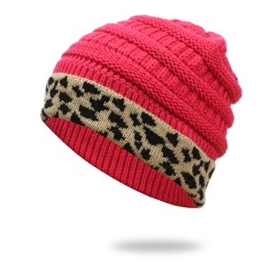 Close-up of pink cable knit beanie with leopard print cuff and warm inner lining