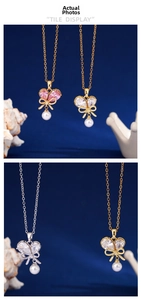 Detail of bowknot necklace featuring heart crystal and pearl pendant on blue texture