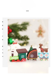 Close-up of a green wooden Christmas train with a reindeer and tree on snowy ground