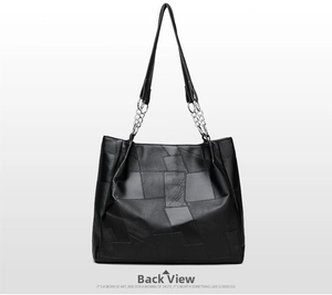 Detail view of the black tote bag back showing geometric patchwork and chain strap