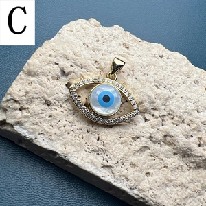 Detailed view of evil eye pendant with gold plating and cubic zirconia on rock base