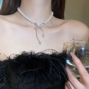 Elegant pearl necklace with sparkling rhinestone butterfly pendant on a female model