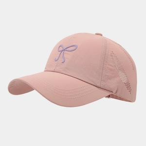 Detail of pink quick-dry baseball cap featuring laser-cut ventilation and a bow logo