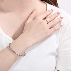 Detailed view of silver bamboo joint style stainless steel ring and bracelet on model