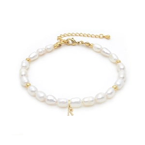 Detail view of natural freshwater pearl bracelet with a gold letter R diamond pendant